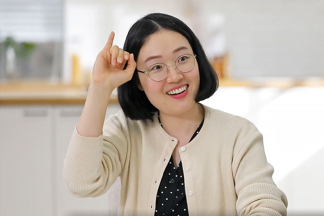 a woman is laughing and talking in sign language