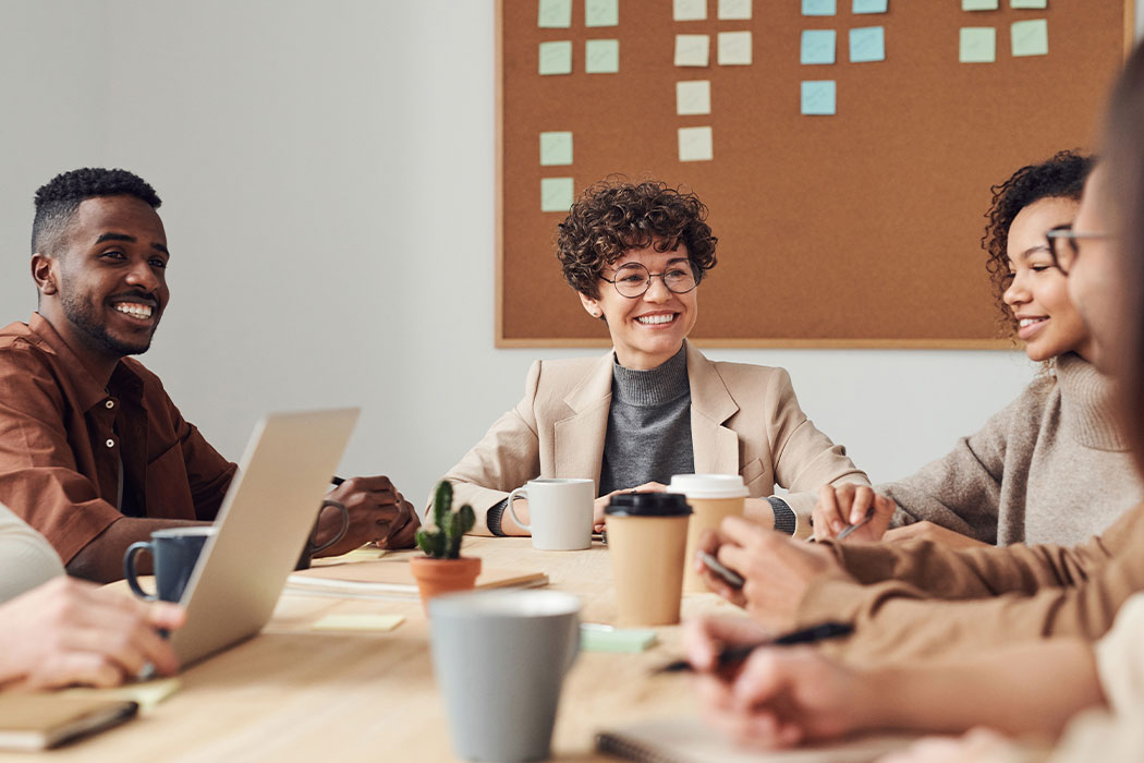 employees of various races are laughing and talking on the table