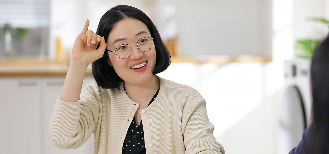 a woman is laughing and talking in sign language