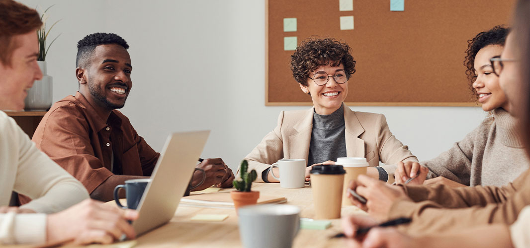 employees of various races are laughing and talking on the table